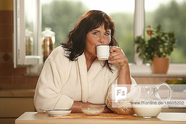 Frau beim Frühstück  Frühstück  frühstücken  Kanne Milch  Schüsseln  Müsli  Tasse Kaffee  frühstückt