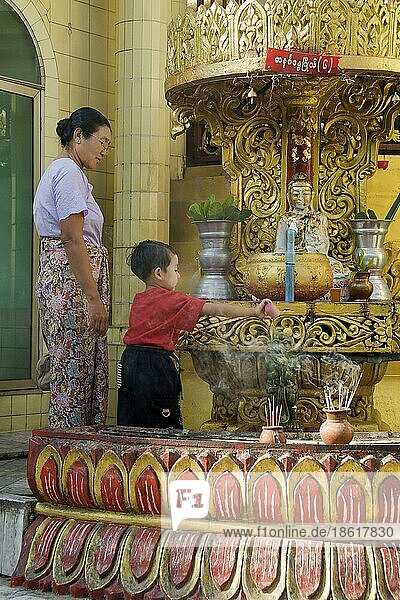 Kind gießt heiliges Wasser auf Buddha  Sule-Pagode  Yangon  Burma  Myanmar  Rangun  Asien
