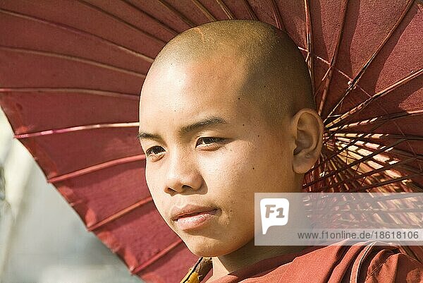 Junger buddhistischer Mönch mit Sonnenschirm  Mingun  Burma  Myanmar  Asien