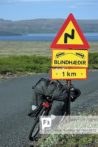 Schwer beladenes Tourenrad  das gegen ein Verkehrsschild lehnt  Island  Europa