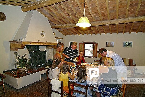 Family at the dining table in holiday apartment  Castelfalfi  Tuscany  Italy  Europe