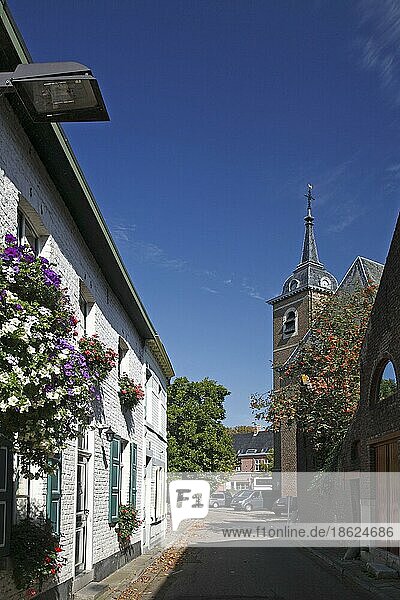 Kirchturm und weiße  blumengeschmückte Häuser im alten Zentrum von Oud-Rekem  Maasland  Belgien  Europa