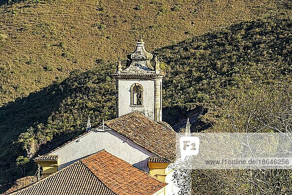 Kirche und ihr Glockenturm von hinten gesehen mit dem Hügel und seiner Vegetation im Hintergrund in der Stadt Ouro Preto  Brasilien  Südamerika