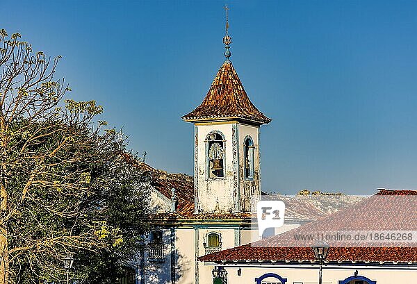 Glockenturm einer Barockkirche  der durch die Bäume und Dächer der historischen Stadt Diamantina in Minas Gerais  Brasilien  ragt  Südamerika