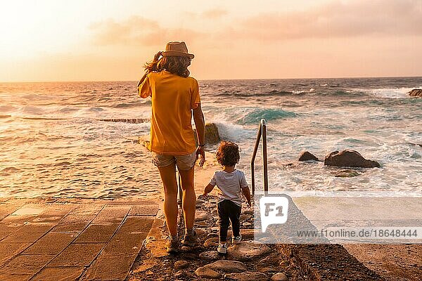Mutter und Sohn bei Sonnenuntergang in den natürlichen Pools von La Maceta auf El Hierro  Kanarische Inseln