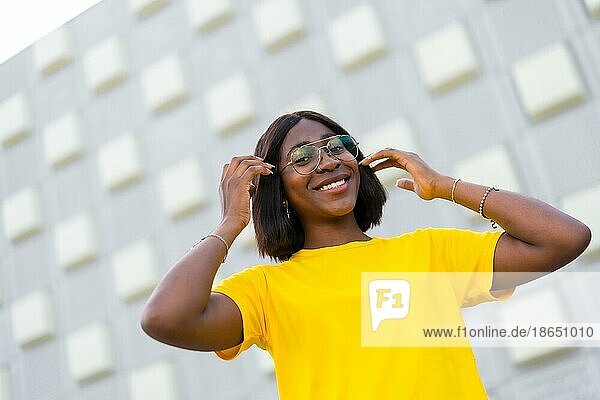 Stylische schwarze Frau in gelbem T Shirt: Ein lebendiges Porträt urbaner Mode und Zuversicht