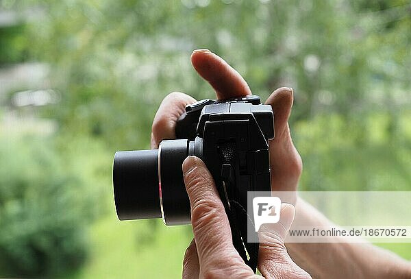 Unrecognisable person holding photo camera  taking pictures