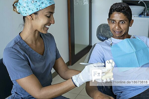 Junger männlicher Patient besucht Zahnarztpraxis. Kurzes Haar Männchen mit gesunden geraden weißen Zähnen sitzen auf Zahnarztstuhl und wartet seinen Arzt. Zahnklinik Hintergrund für Copy Space Text