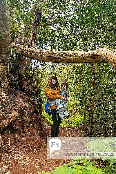 Porträt von Mutter und Sohn in einem Baum auf einem Wanderweg im moosbewachsenen Wald des Nationalparks Garajonay  La Gomera  Kanarische Inseln. Auf dem Ausflug nach Las Creces