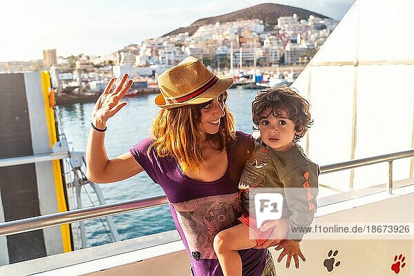 Mother and son on vacation on the ferry and the city of Los Cristianos in the background on the island of Tenerife. Ferry coming from La Gomera  Canary Islands