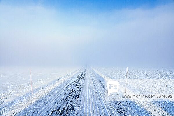Glatte Winterstraße bei Nebel  Schnee und schlechter Sicht auf dem Lande