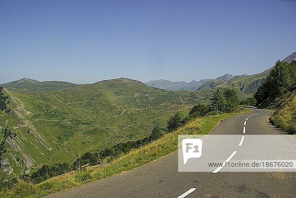 Gewundene Bergstraße mit Berggipfeln im Hintergrund in den sommerlichen Pyrenäen  Frankreich  Europa