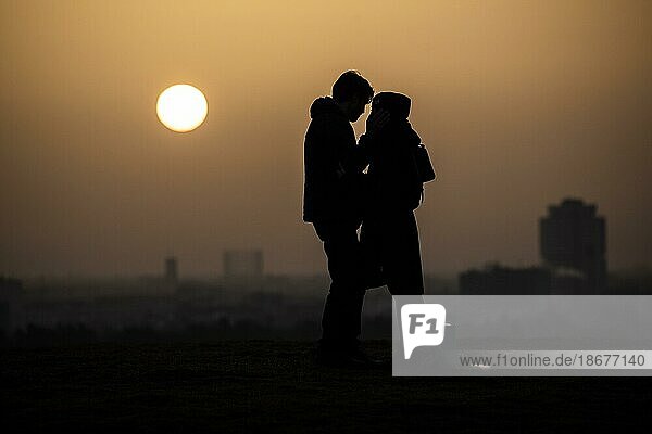 Two people silhouetted against the rising sun in Berlin  25.02.2021. Copyright: Berlin  Germany  Europe