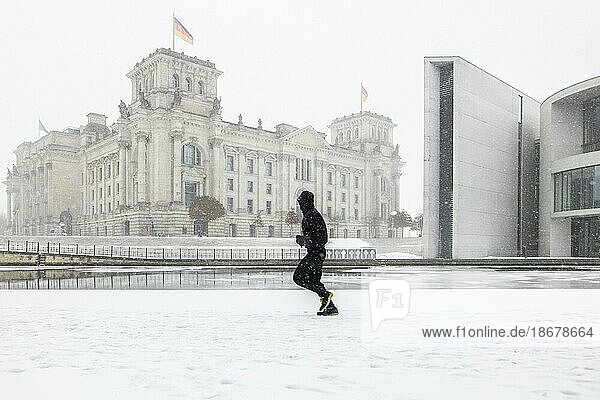Berlin  Eine Person zeichnet sich am Spreebogen zwischen Reichstagsgebäude und Paul  Löbe  Haus ab  aufgenommen während starken Schneefalls in Berlin