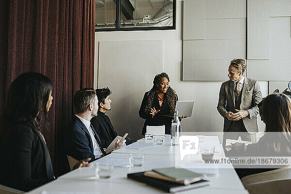 Unternehmerin im Gespräch mit männlichen und weiblichen Kollegen während eines Geschäftstreffens im Büro