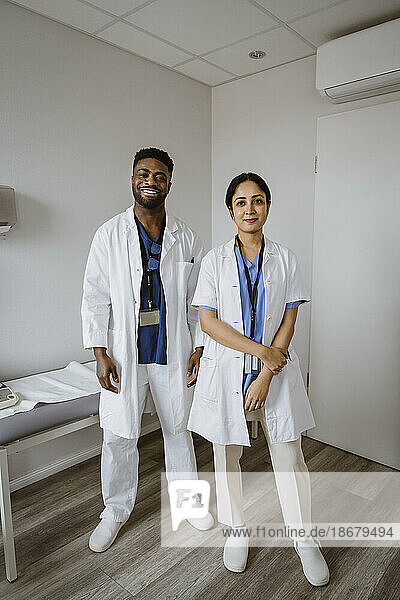 Portrait of confident male and female healthcare workers standing in consulting room