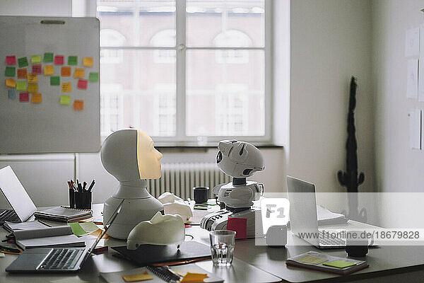 Moderne Sozialroboter mit Laptops auf dem Schreibtisch im Innovationslabor