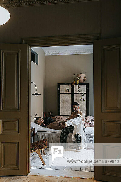 Paar im Schlafzimmer  gesehen durch die Türöffnung zu Hause