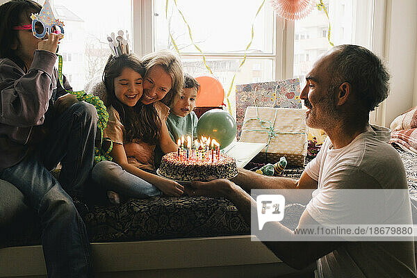 Glückliche Familie feiert Geburtstag mit Kuchen zu Hause