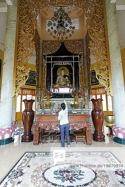 Tinh Xa Ngoc Chau pagoda  Buddhist altar and woman praying to the Buddha  Chau Doc  Vietnam  Indochina  Southeast Asia  Asia