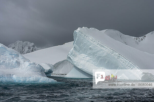 Tourists in an inflatable boat exploring Pleneau Island  Antarctica  Polar Regions