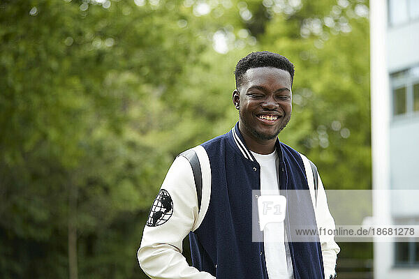 Smiling young man in baseball jacket