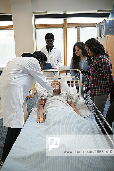 Medical students (16-17) performing medical exam on dummy