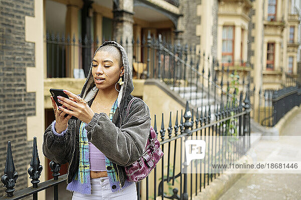 Hipster young woman using phone in street