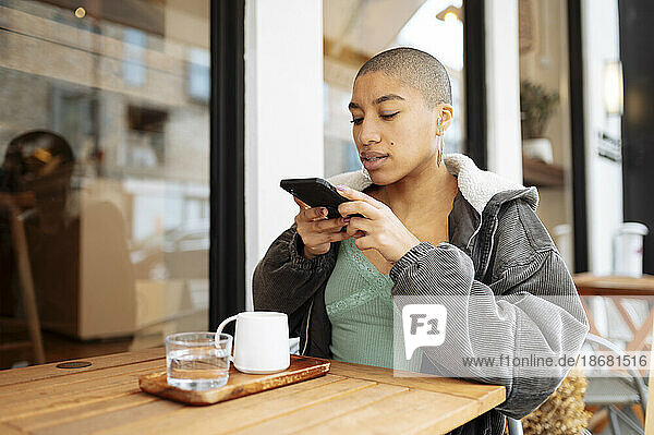 Hipster young woman photographing coffee in cafe