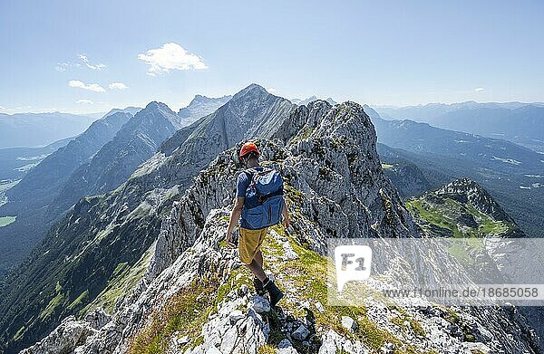 Bergsteiger am Gipfel der Oberen Wettersteinspitze  Blick auf den felsigen Bergkamm des Wettersteingrat  Wettersteingebirge  Bayerische Alpen  Bayern  Deutschland  Europa
