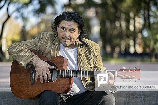 Flamenco Gitarrist sitzt auf einer Treppe und spielt