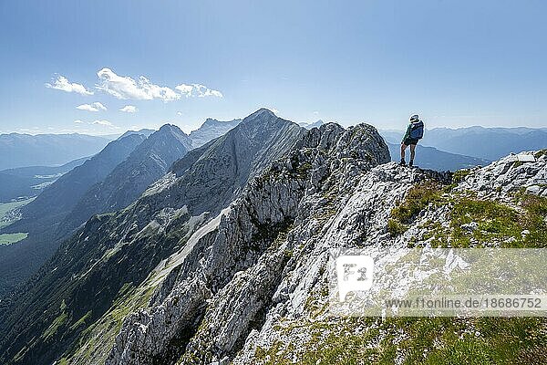 Mountaineer at the summit of the Upper Wettersteinspitze  view of the rocky ridge of the Wetterstein ridge  Wetterstein Mountains  Bavarian Alps  Bavaria  Germany  Europe