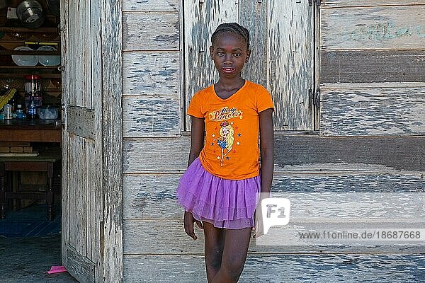 Porträt eines jungen afro surinamischen Mädchens mit geflochtenem Haar vor einem Holzhaus im Dorf Aurora  Bezirk Sipaliwini  Surinam