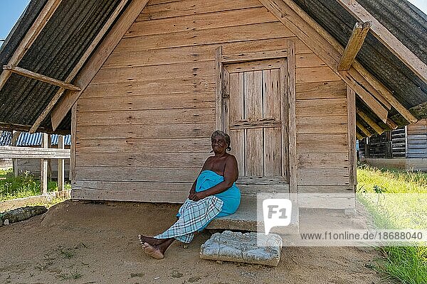 Afro surinamische Frau posiert vor einem Holzhaus im Dorf Aurora  Bezirk Sipaliwini  Suriname  Surinam  Südamerika
