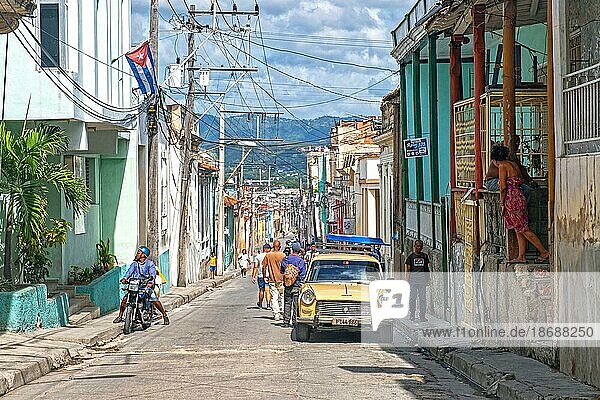Straßenszene mit bunten Häusern und einem alten amerikanischen Auto in Santiago de Cuba  der Hauptstadt der Provinz Santiago de Cuba auf der Insel Kuba  Karibik