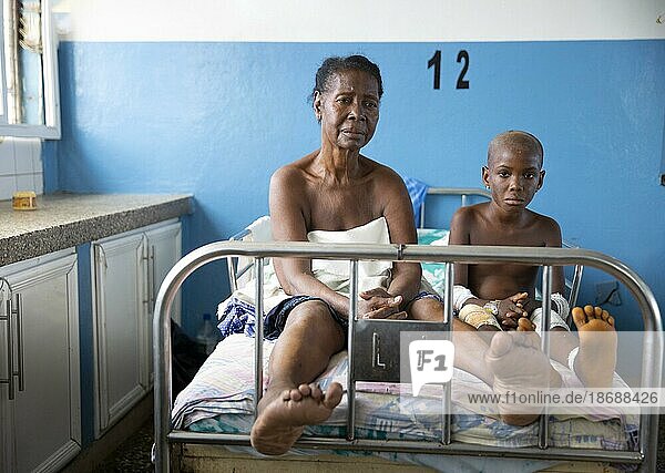 Großmutter und kleine Patientin im Princess Christian Hospital in Sierra Leone  Freetown  15.06.202. Die Großmutter schläft mit ihrer Enkelin gemeinsam im Kinderbett und betreut sie.  Sierra Leone  Afrika