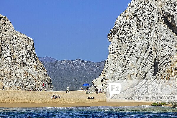 Kalksteinfelsen und Touristen beim Sonnenbaden an einem abgelegenen Strand in der Nähe des Badeorts Cabo San Lucas auf der Halbinsel Baja California Sur  Mexiko  Mittelamerika