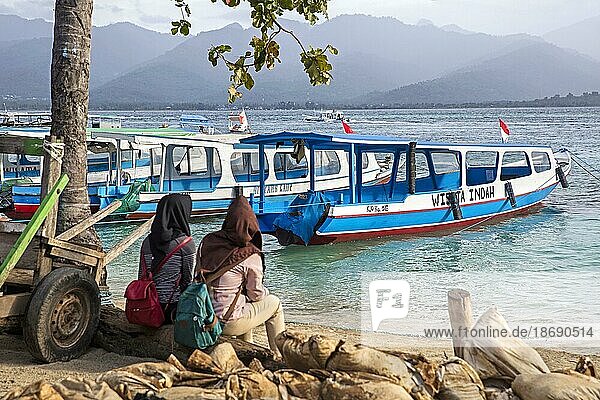 Zwei indonesische Frauen warten auf die Fähre zur Insel Lombok auf Gili Air  einer der Gili Inseln in Indonesien