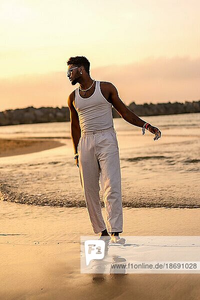 Portrait of black ethnic model enjoying summer vacation by the sea wearing a tank top