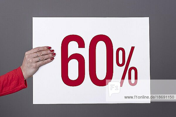 Weibliche Hand hält ein 60% Plakat. Studioaufnahme. Werbekonzept