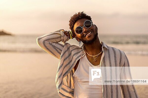 Portrait of black ethnic model enjoying summer vacation by the sea smiling