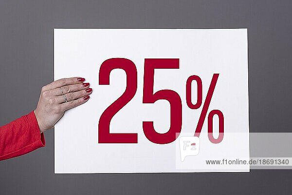 Weibliche Hand hält ein 25% Plakat. Studioaufnahme. Werbekonzept