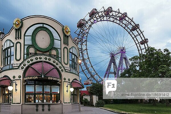 Eingang zum öffentlichen Park in Wien  Österreich  bekannt als Praterpark und sein historisches Riesenrad oder Wiener Riesenrad in der bewölkten Abenddämmerung. Cafés im Freien  Unterhaltung. Jugendstil im Vintage Stil. Touristenattraktion  Wochenendaktivitäten  Europa