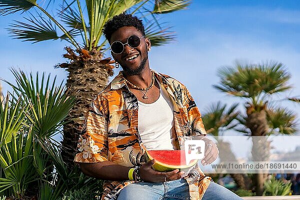 Porträt eines schwarzen ethnischen Mannes genießen Sommerurlaub am Strand mit einer Wassermelone Spaß haben