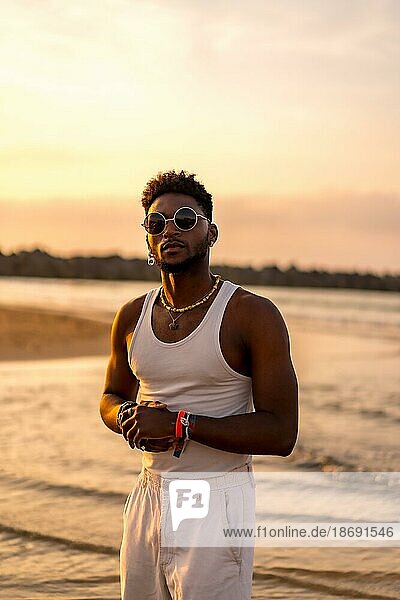Portrait of black ethnicity model enjoying summer vacation by the sea wearing sunglasses