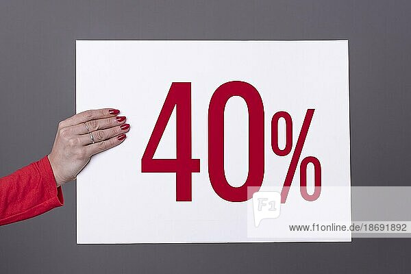 Weibliche Hand hält ein 40% Plakat. Studioaufnahme. Werbekonzept