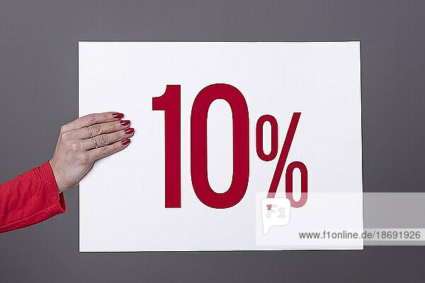 Weibliche Hand hält ein 10% Plakat. Studioaufnahme. Werbekonzept