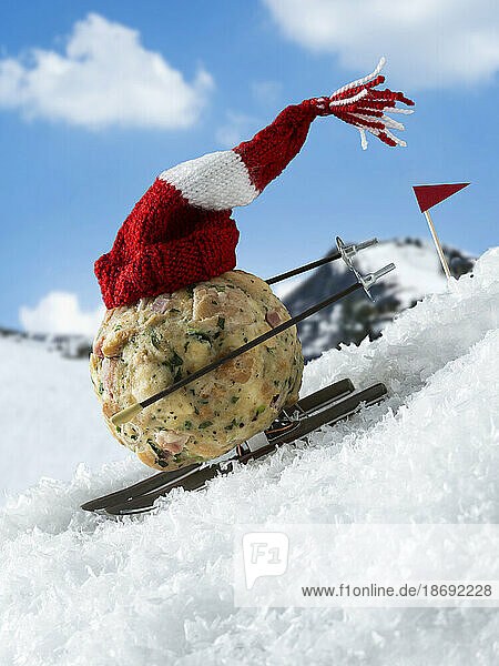 Semmelknoedel mit rot-weiss-roter Strickmuetze faehrt Ski