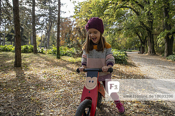 Playful girl riding bicycle at park