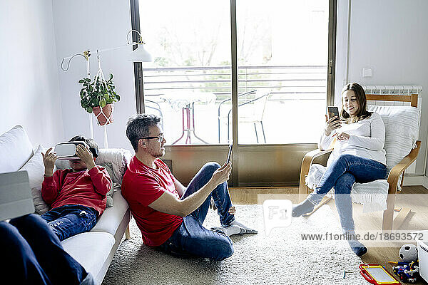 Family using wireless technologies in living room at home